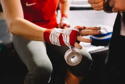 A woman wrapping her fists for a fight
