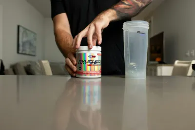 An athlete preparing his pre-workout supplement
